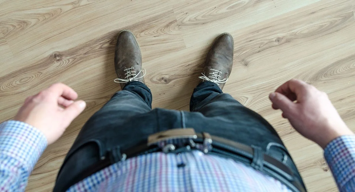 A top-down view of a man's outfit, showcasing a casual business look with shoes and checkered shirt.